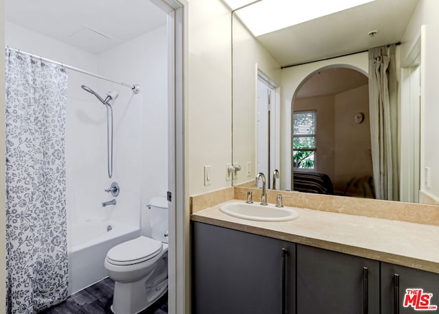 full bathroom featuring vanity, hardwood / wood-style flooring, shower / bath combination with curtain, and toilet