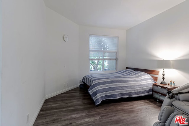 bedroom with dark hardwood / wood-style flooring