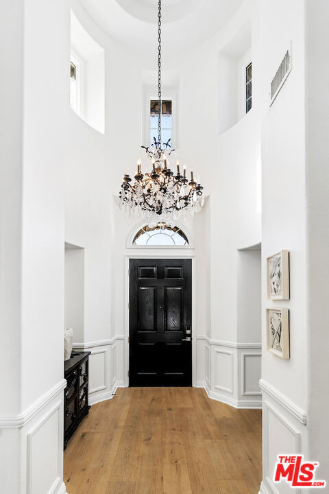 entrance foyer featuring wood-type flooring and a notable chandelier