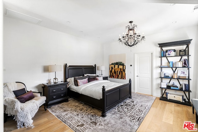 bedroom with a chandelier and hardwood / wood-style floors