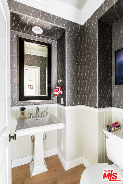 bathroom with hardwood / wood-style flooring and toilet