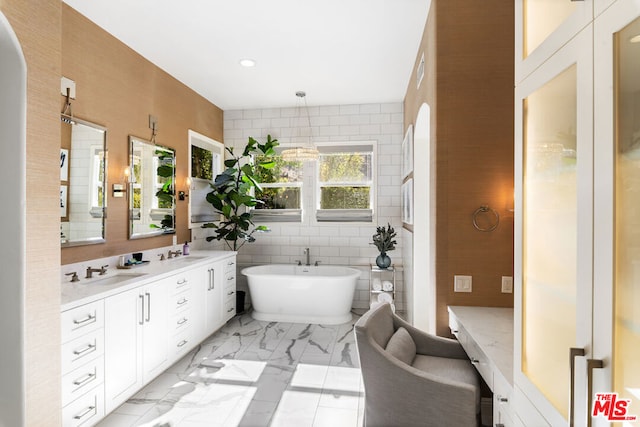 bathroom with vanity, a bathing tub, and tile walls