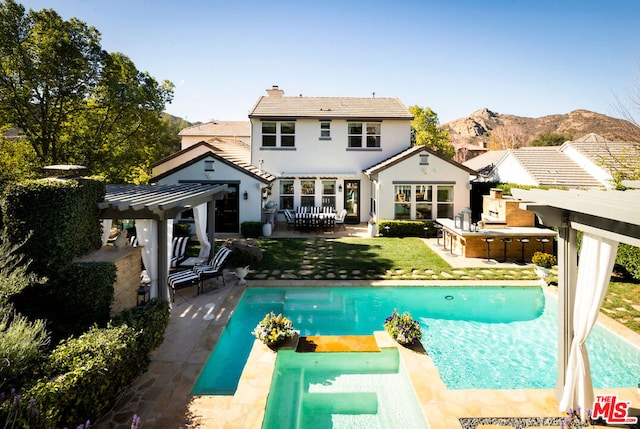 rear view of house featuring a mountain view and a patio