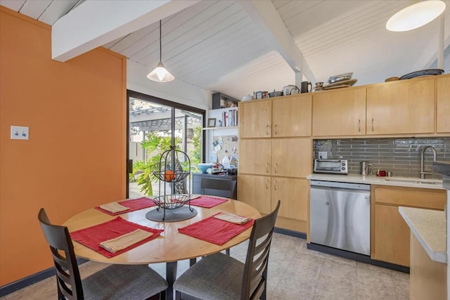 kitchen featuring light brown cabinetry, hanging light fixtures, stainless steel dishwasher, and sink