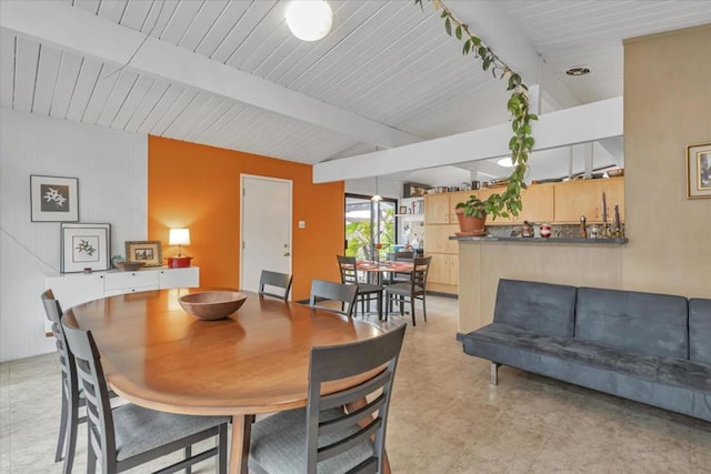 dining space featuring vaulted ceiling with beams