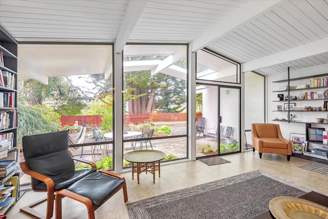 sunroom featuring lofted ceiling with beams and a healthy amount of sunlight