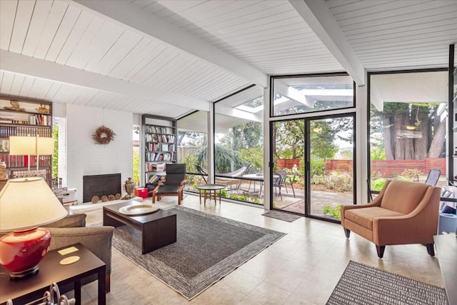 interior space with vaulted ceiling with beams, a wealth of natural light, and a large fireplace