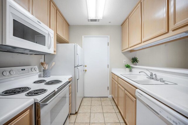 kitchen with sink, white appliances, light tile patterned floors, and light brown cabinets