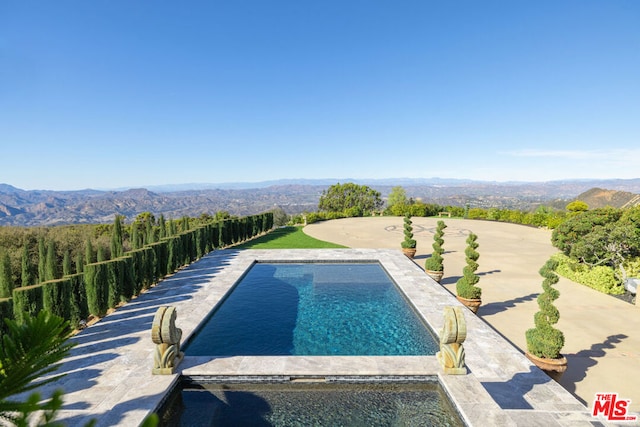 view of swimming pool featuring a mountain view and a patio area