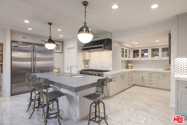 kitchen featuring sink, appliances with stainless steel finishes, range hood, a center island with sink, and decorative backsplash