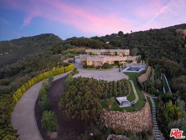 aerial view at dusk featuring a mountain view