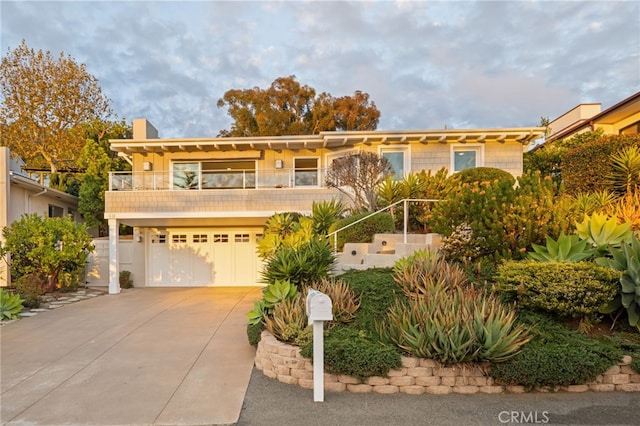 view of front of property featuring a balcony and a garage