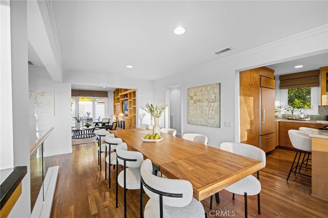 dining space with crown molding and dark hardwood / wood-style floors