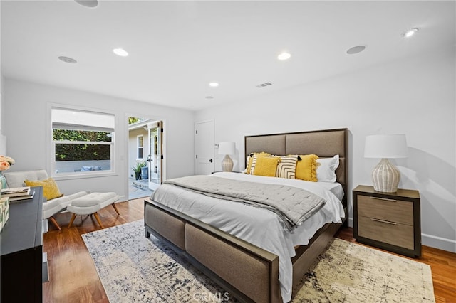 bedroom featuring wood-type flooring and access to exterior