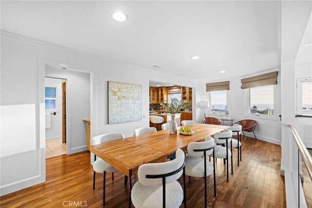 dining space featuring ornamental molding and wood-type flooring