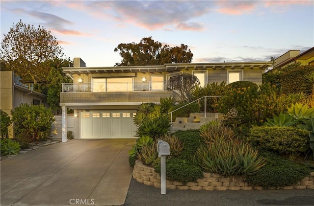 331 Ledroit St, Laguna Beach, CA 92651 - view of front facade with a garage, a balcony, driveway, and a chimney
