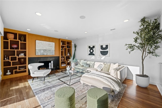 331 Ledroit St, Laguna Beach, CA 92651 - living area with built in features, a warm lit fireplace, recessed lighting, visible vents, and wood finished floors