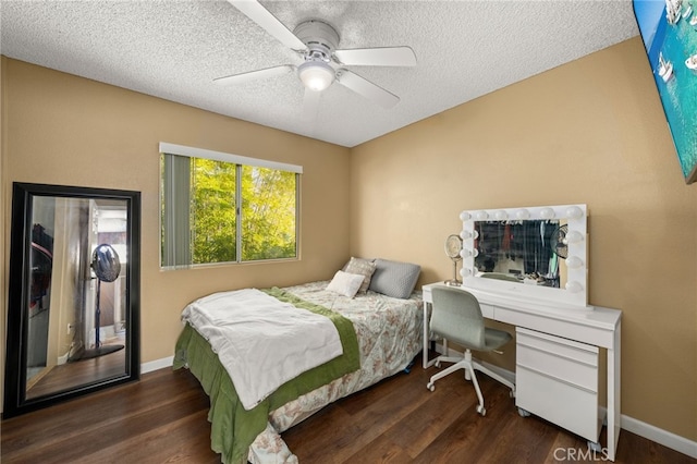 bedroom with ceiling fan, dark hardwood / wood-style flooring, and a textured ceiling