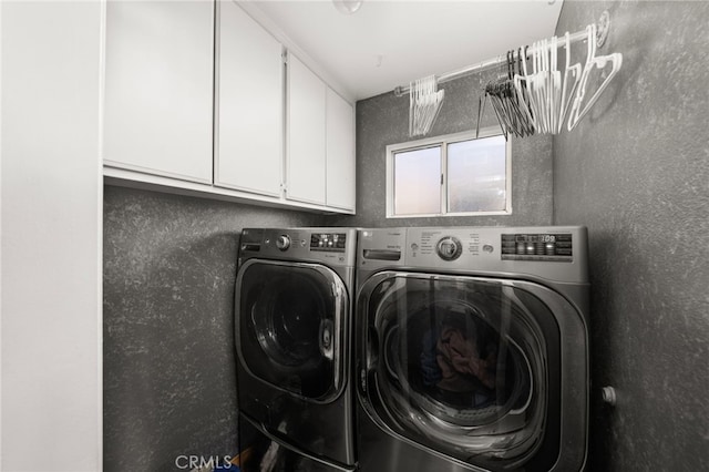 washroom with cabinets and washing machine and dryer