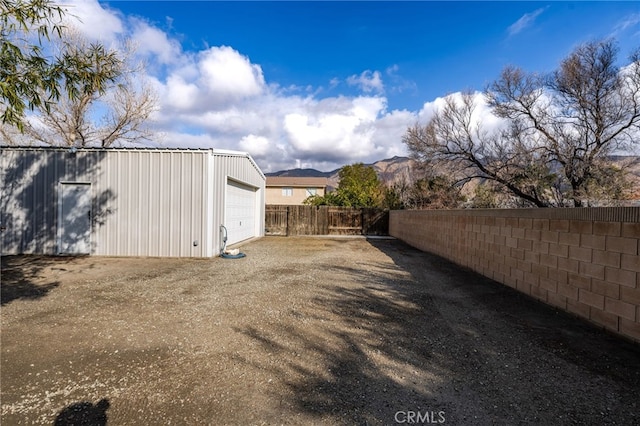 view of yard featuring an outbuilding, a garage, and a mountain view