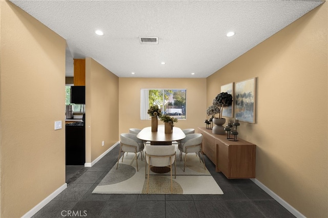 dining space featuring a healthy amount of sunlight and a textured ceiling