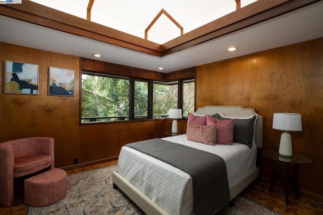 bedroom with parquet floors and wood walls