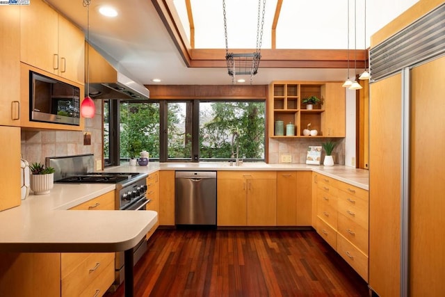 kitchen with dark wood-type flooring, built in appliances, decorative light fixtures, kitchen peninsula, and light brown cabinets