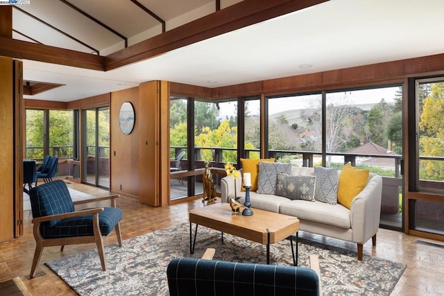 sunroom / solarium featuring vaulted ceiling and a mountain view