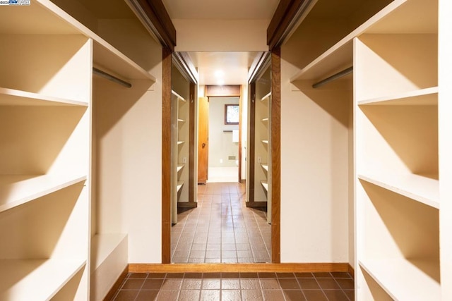 spacious closet featuring dark tile patterned flooring