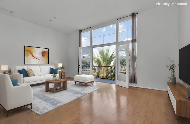 living room with a towering ceiling and light hardwood / wood-style floors