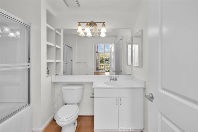 full bathroom with vanity, hardwood / wood-style floors, enclosed tub / shower combo, and toilet