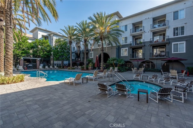 view of swimming pool with a hot tub and a patio area