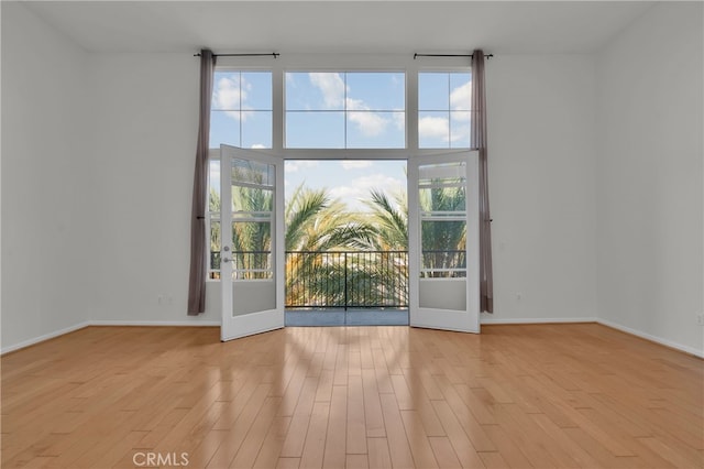 unfurnished room with french doors and light wood-type flooring