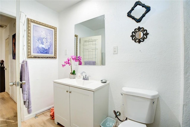 bathroom featuring vanity, hardwood / wood-style floors, and toilet