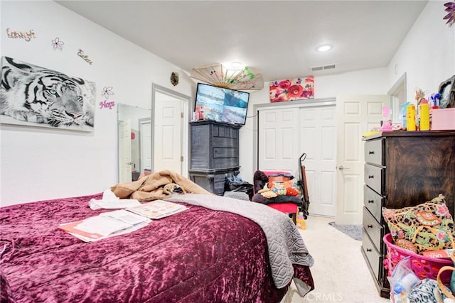 bedroom featuring light carpet and a closet