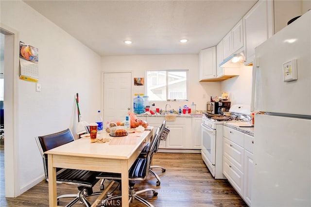 kitchen with wood-type flooring, sink, white cabinets, and white appliances