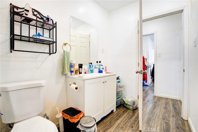 bathroom with hardwood / wood-style flooring, vanity, and toilet