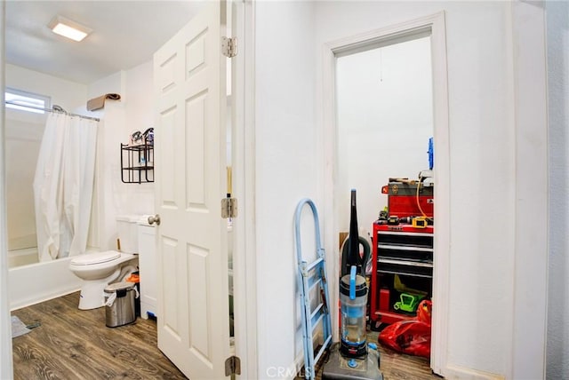 bathroom with wood-type flooring, toilet, and shower / bath combo