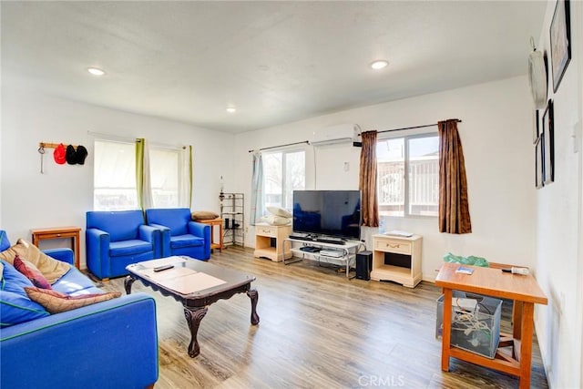 living room featuring wood-type flooring and a wall mounted AC