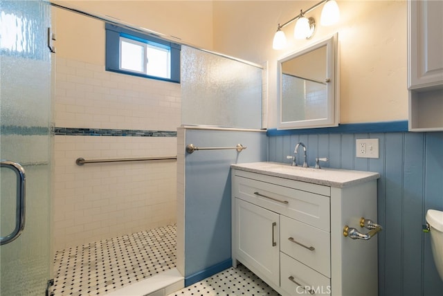 bathroom with a tile shower, vanity, and toilet