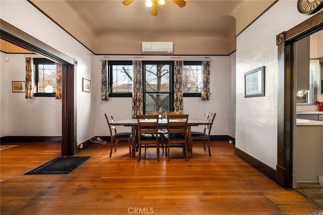 dining space featuring hardwood / wood-style floors and a wall unit AC