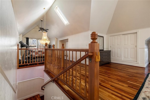 staircase featuring wood-type flooring and vaulted ceiling with skylight