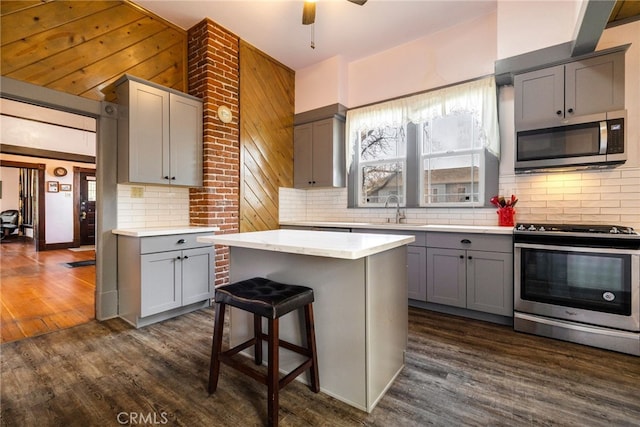 kitchen featuring gray cabinets, a kitchen island, a wealth of natural light, sink, and stainless steel appliances