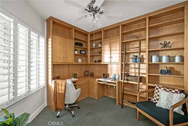 carpeted home office featuring ceiling fan and built in desk