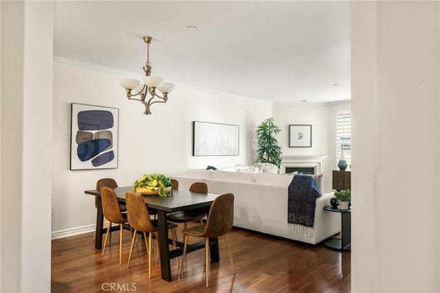 dining room with ornamental molding, dark hardwood / wood-style floors, and a notable chandelier