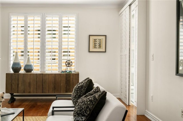 sitting room featuring ornamental molding, wood-type flooring, and a healthy amount of sunlight