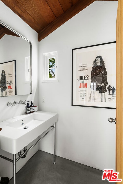 bathroom with lofted ceiling, concrete floors, and wood ceiling