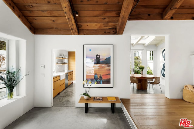 hall with beamed ceiling, concrete flooring, and wood ceiling