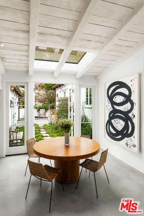 sunroom featuring beam ceiling