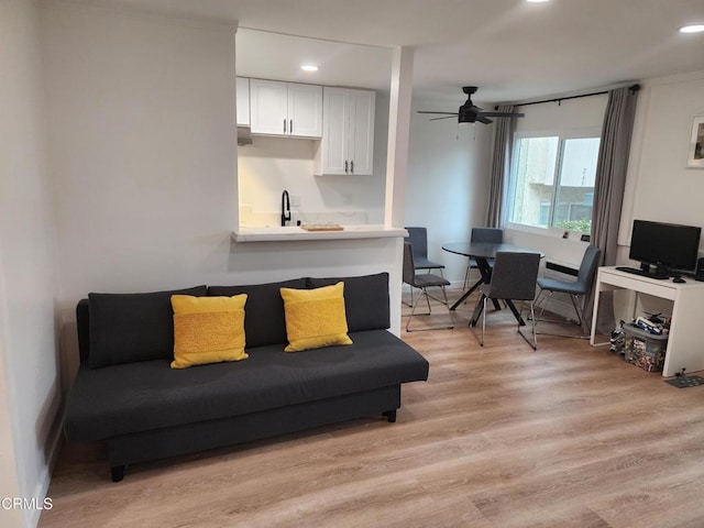 living room featuring light hardwood / wood-style flooring and ceiling fan